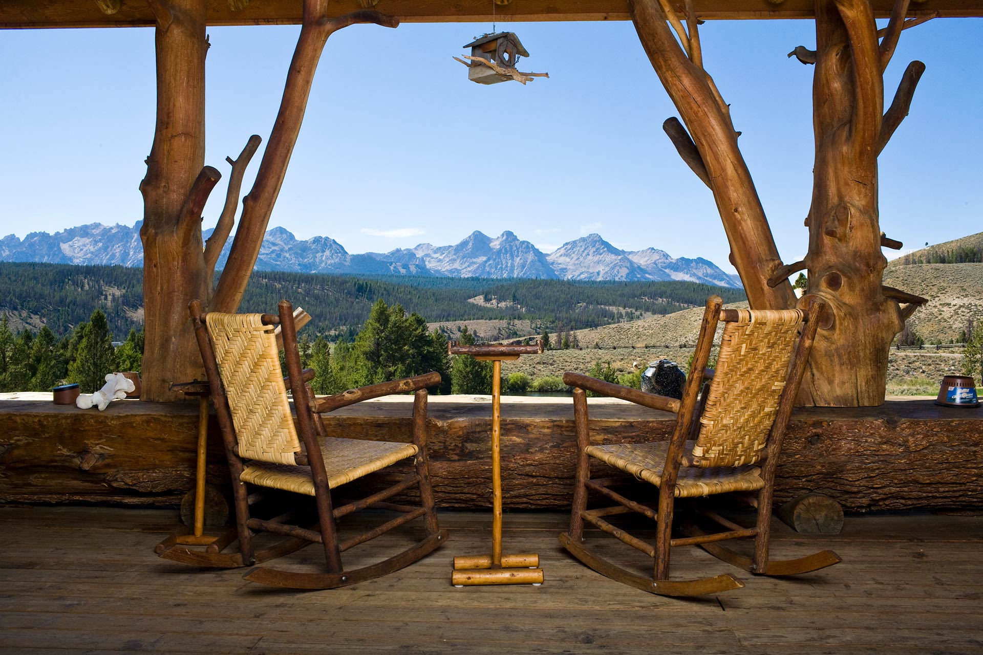 Relaxing on the porch overlooking a forest and the sawtooth mountains at a rocky mountain lodge and cabins